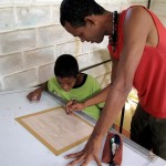 dede-medium Dedê Galdino Santana helps a young student with his drawing.